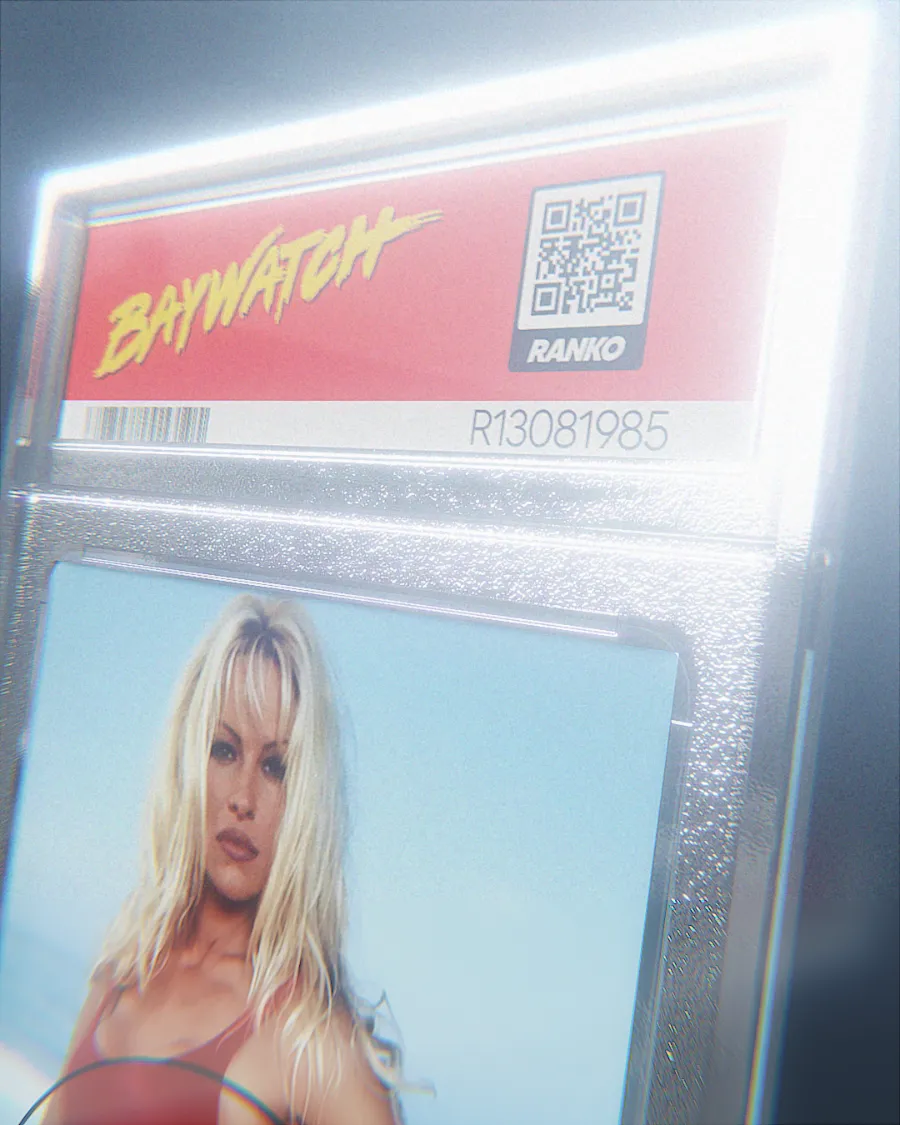Photo d'une cabine téléphonique ou d'un kiosque avec une enseigne « BayWatch » en lettres jaunes stylisées, un code QR et la photo d'une femme blonde en haut rouge.