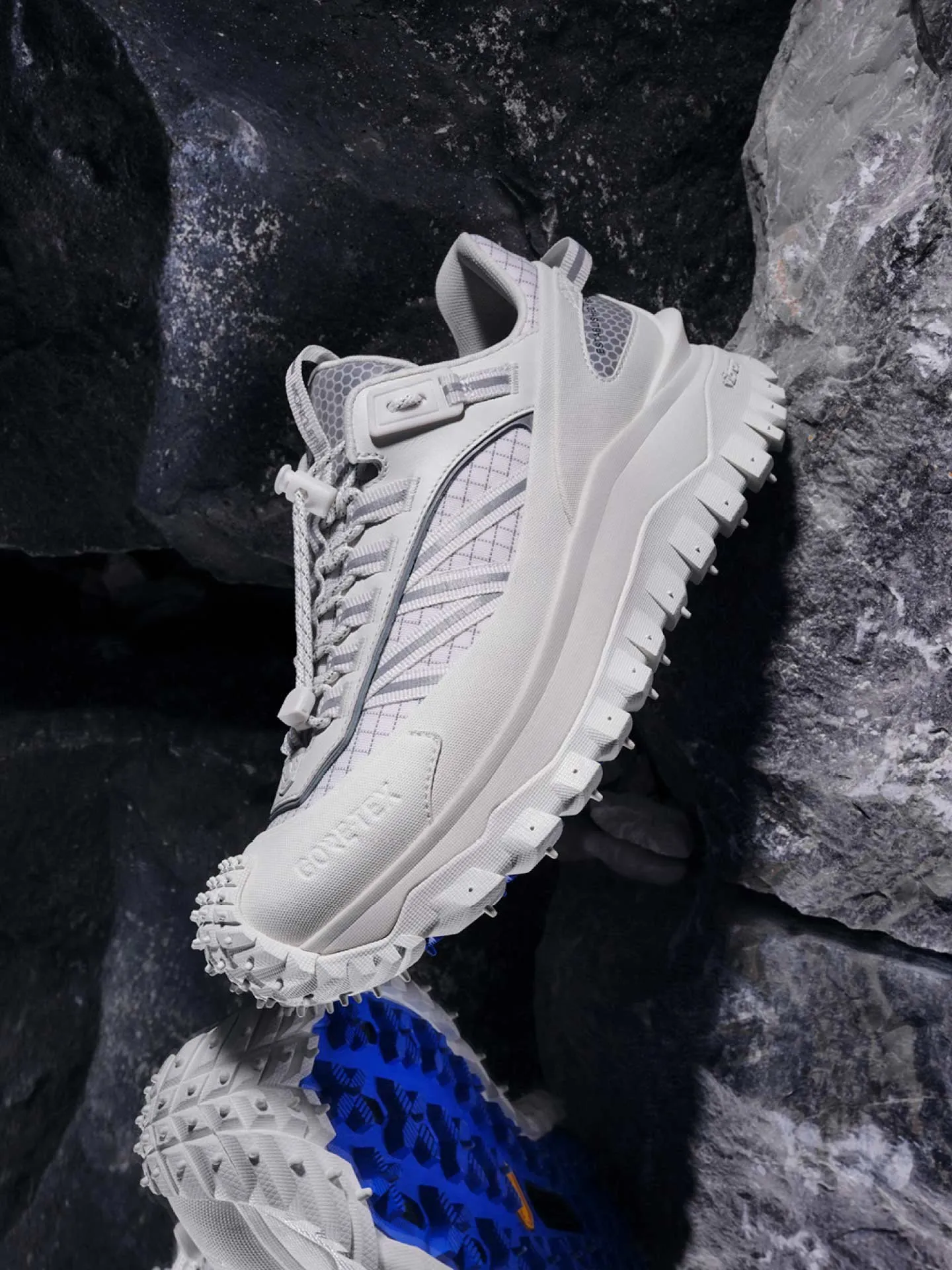 Chaussure de randonnée Moncler à semelle texturée sur des rochers sombres